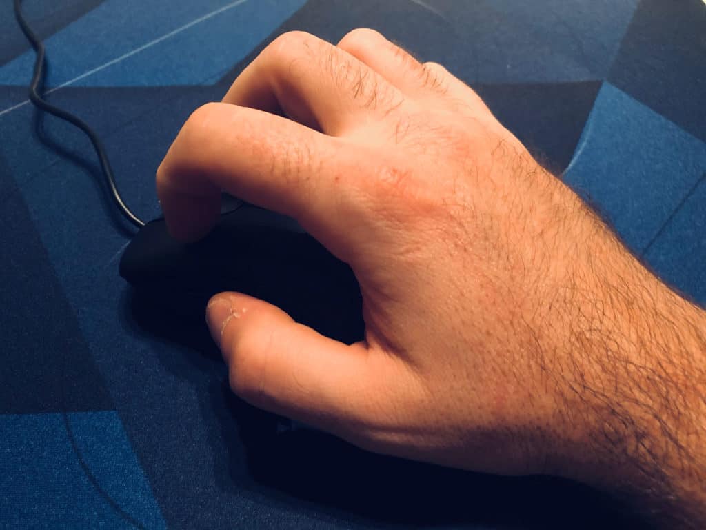 Gros plan sur une main tenant une souris de la gamme Zowie série EC