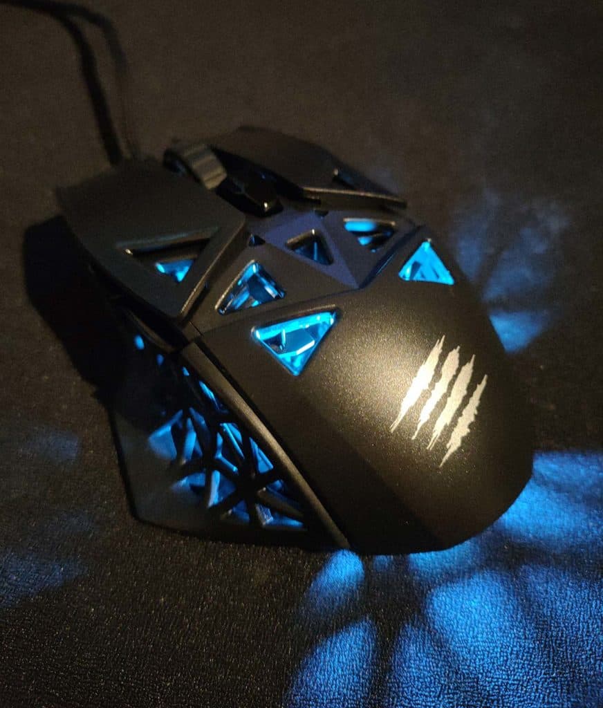 La Mad Catz MOJO M1 allumée posée sur un tapis de souris