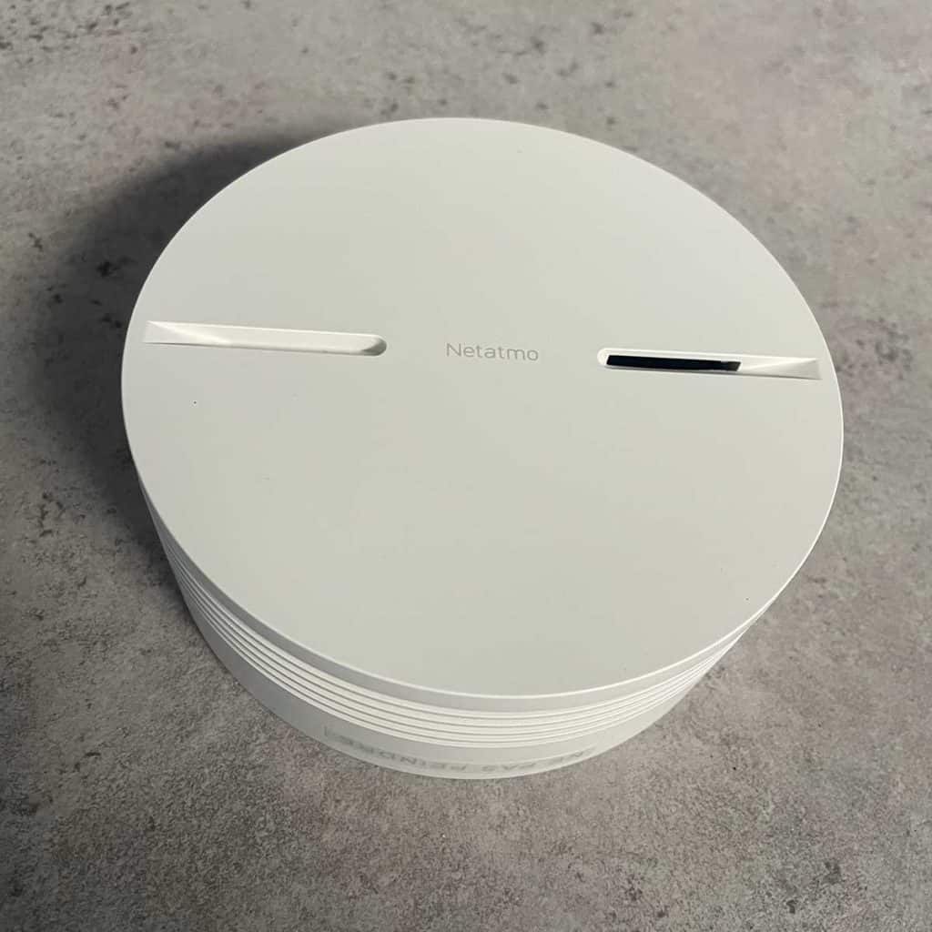 Gros plan sur le Détecteur de fumée Intelligent Netatmo posé sur une table