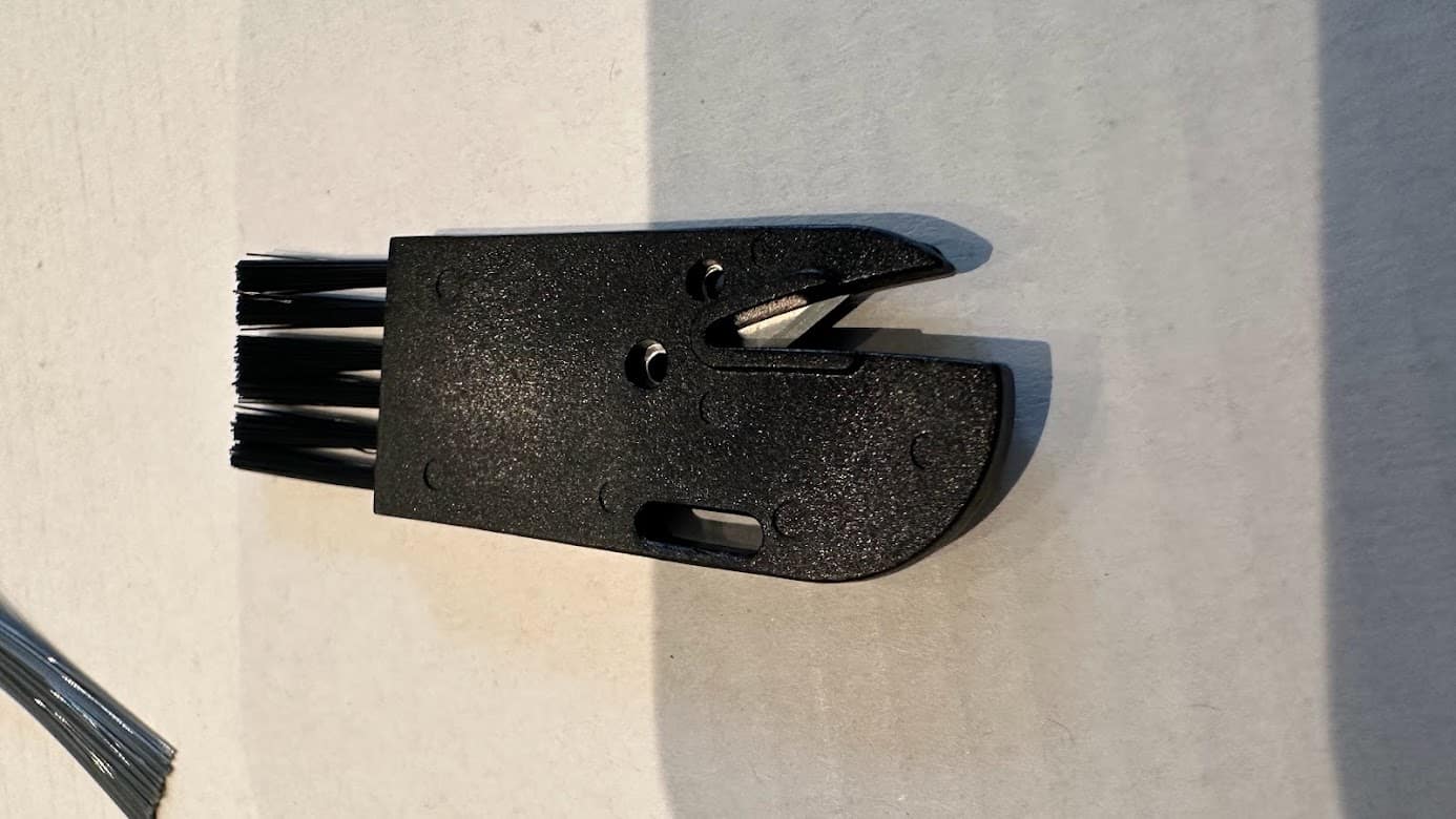 OKP K2 : la brosse de nettoyage contient un petit cutter pour couper les cheveux qui s'emellent sur les brosses : c'est bien pensé!