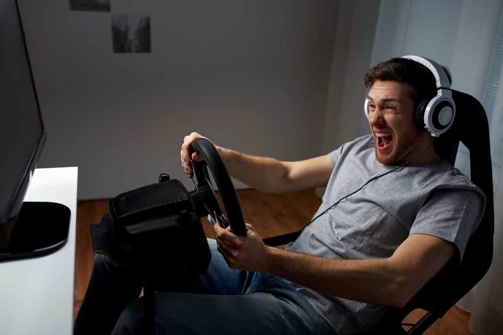 Un homme jouant à un jeu de course au volant