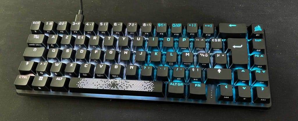 Le Corsair K65 Pro Mini allumé et posé sur un bureau
