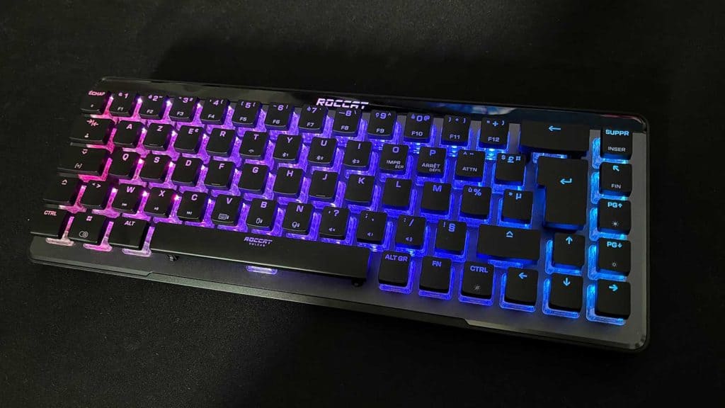 Le Roccat Vulcan II Mini Air allumé posé sur un grand tapis de souris