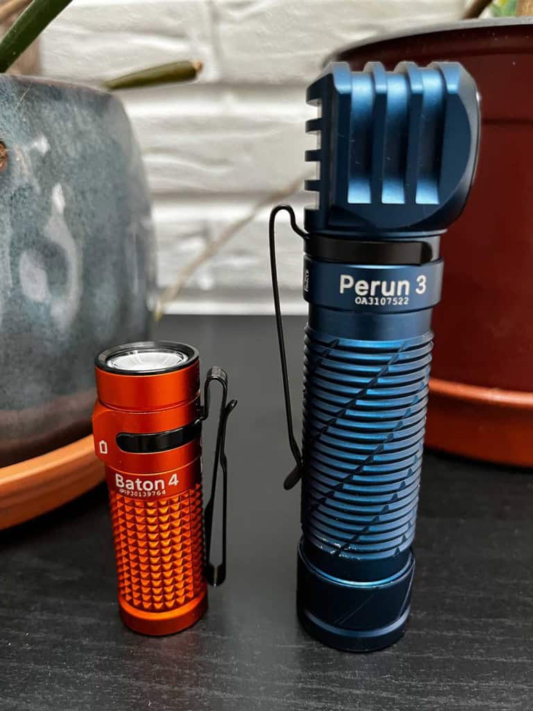 La lampe Olight Perun 3 posée sur une table à côté de la Baton 4