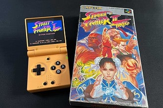 La Miyoo Mini Flip à côté d'un jeu vidéo