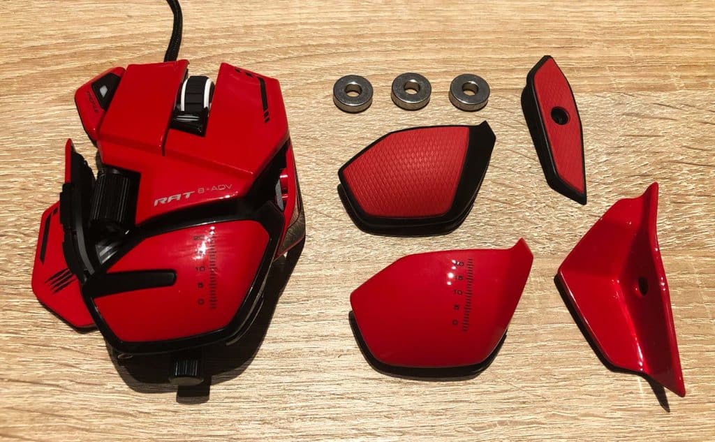 La souris Mad Catz RAT 8+ ADV posée sur une table avec ses nombreux accessoires