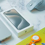 a table with an iphone, mouse, and other electronics
