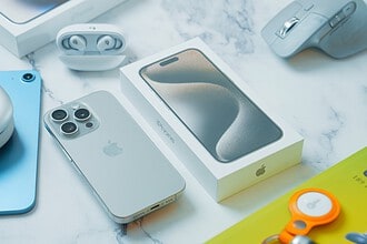 a table with an iphone, mouse, and other electronics