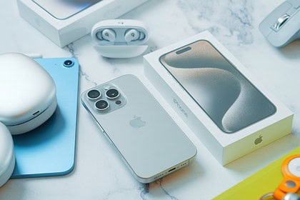 a table with an iphone, mouse, and other electronics