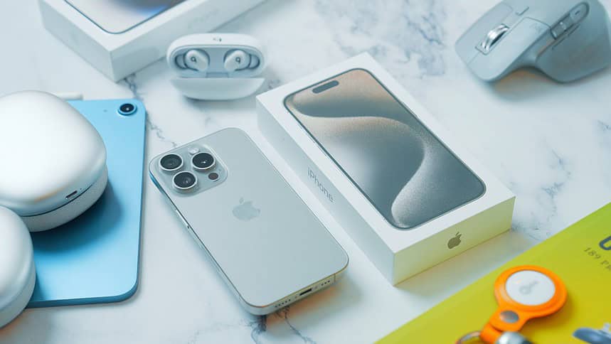 a table with an iphone, mouse, and other electronics