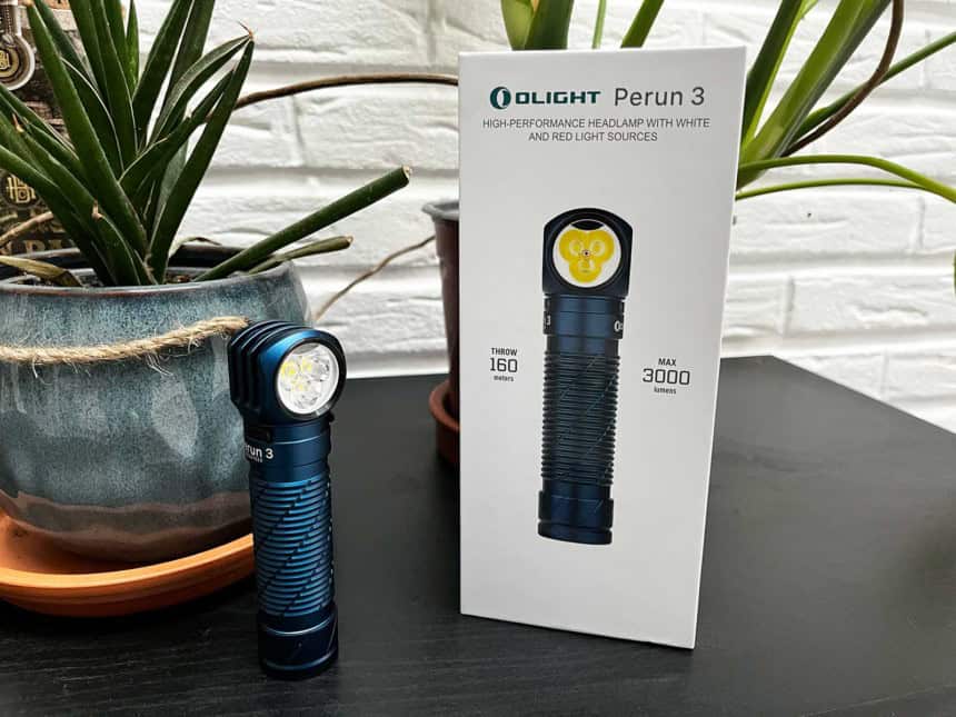 La lampe Olight Perun 3 posée sur une table à côté de sa boite
