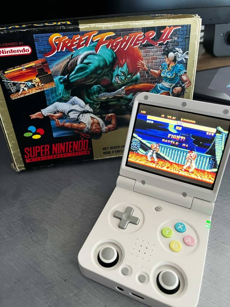 La Miyoo Flip V2 à côté d'un jeu rétro