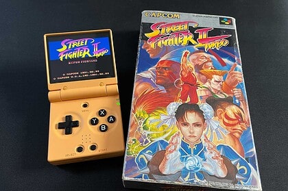 La Miyoo Mini Flip à côté d'un jeu vidéo