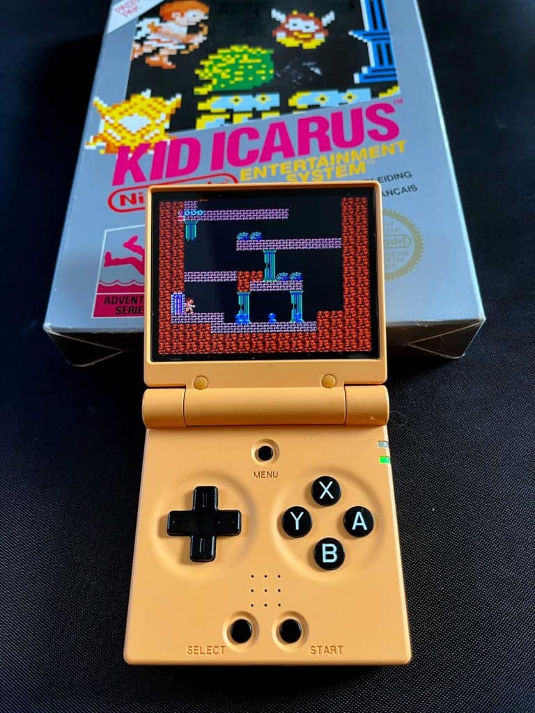 La Miyoo Mini Flip à côté d'un jeu vidéo